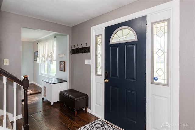 entrance foyer featuring a healthy amount of sunlight, baseboards, stairway, and dark wood-type flooring