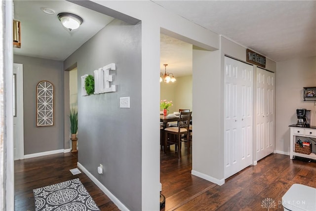 corridor featuring baseboards and hardwood / wood-style floors