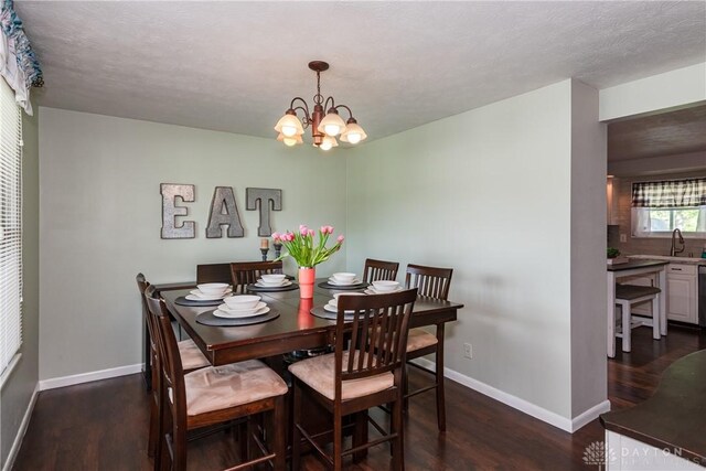 dining room with an inviting chandelier, baseboards, and dark wood-style floors