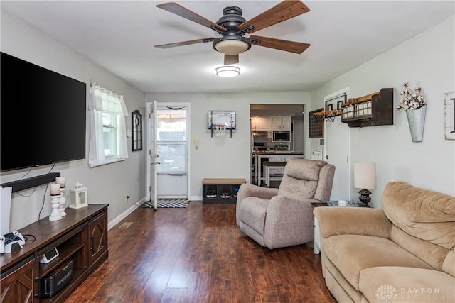 living room with baseboards, ceiling fan, and wood finished floors