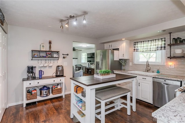 kitchen with a sink, open shelves, appliances with stainless steel finishes, and white cabinets