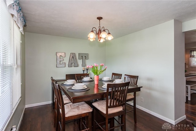 dining area with baseboards, wood finished floors, and a chandelier