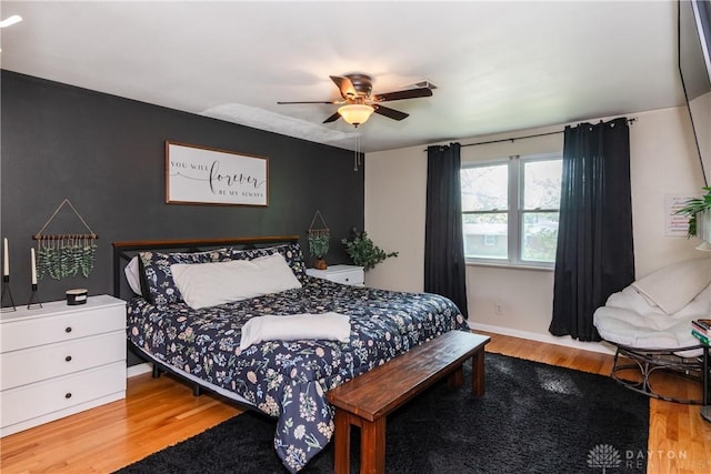 bedroom featuring baseboards, a ceiling fan, and wood finished floors