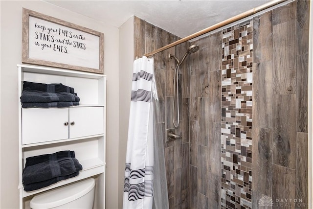 full bath featuring toilet and tiled shower