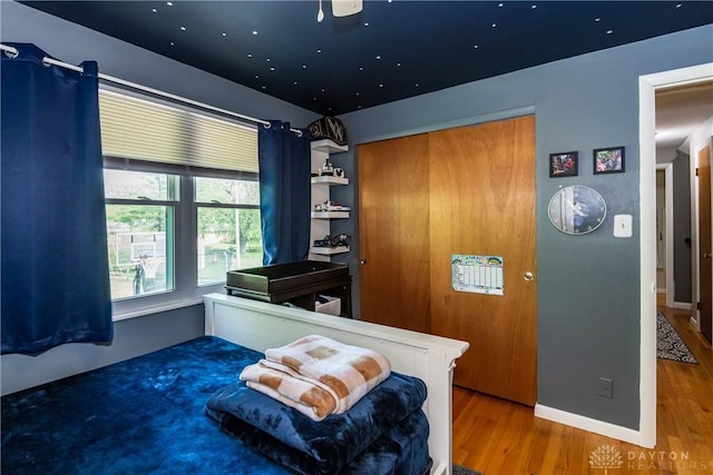 bedroom featuring baseboards, a closet, and wood finished floors