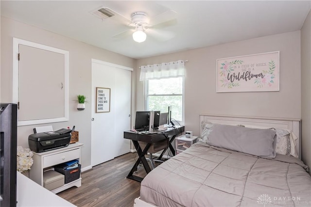 bedroom with visible vents, ceiling fan, wood finished floors, and a closet