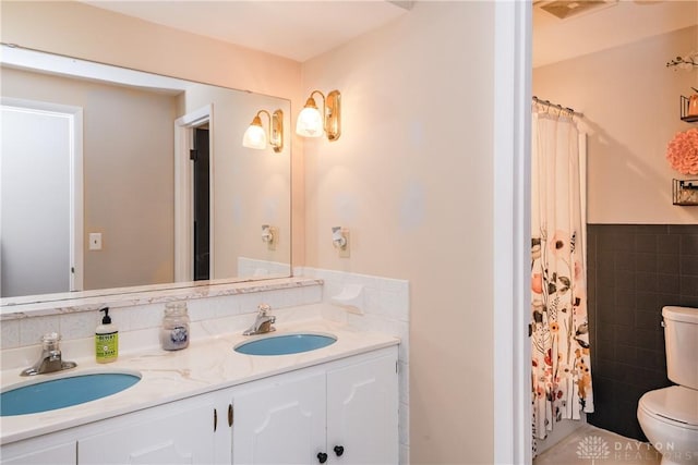 full bathroom featuring visible vents, a sink, toilet, and tile walls
