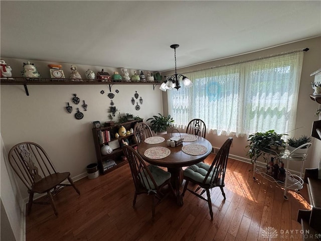 dining area with wood-type flooring, baseboards, a notable chandelier, and plenty of natural light