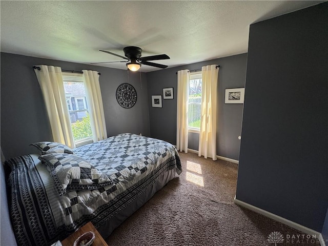 carpeted bedroom featuring a ceiling fan, baseboards, and a textured ceiling