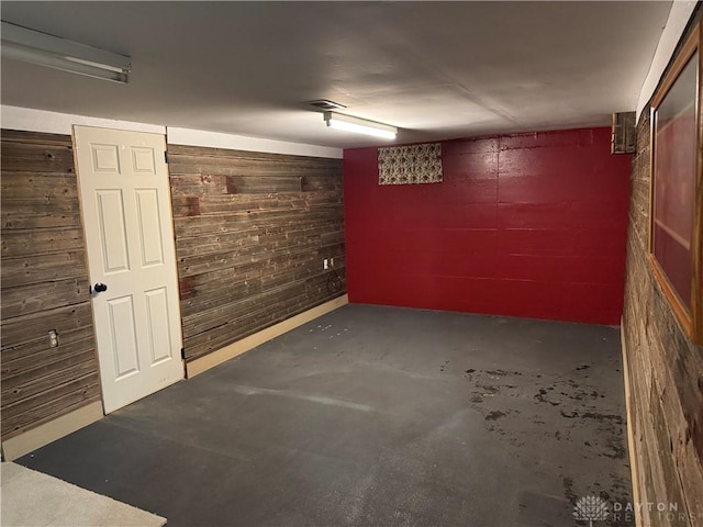 finished basement featuring wooden walls