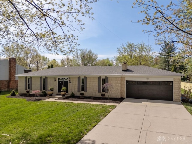 ranch-style house featuring a chimney, a garage, brick siding, a front lawn, and concrete driveway