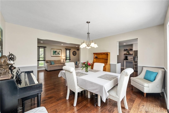dining room with an inviting chandelier, recessed lighting, and wood finished floors