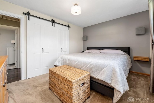 bedroom with carpet floors, a barn door, and a closet