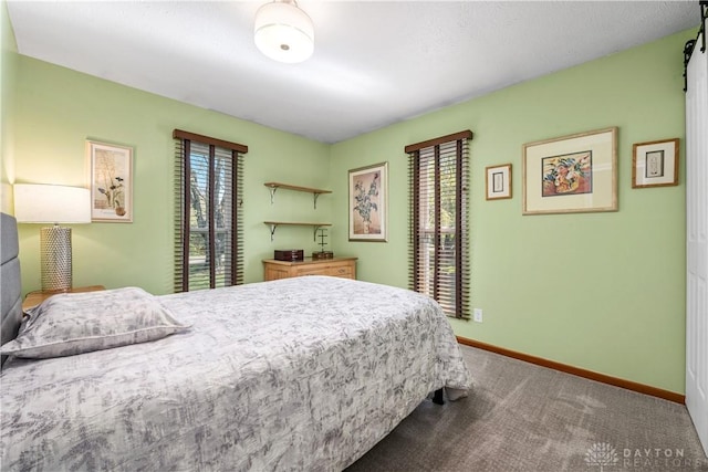 carpeted bedroom featuring baseboards and multiple windows