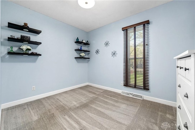 empty room with visible vents, baseboards, and carpet floors