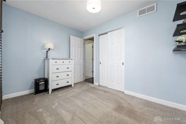 unfurnished bedroom with carpet floors, baseboards, visible vents, and a closet