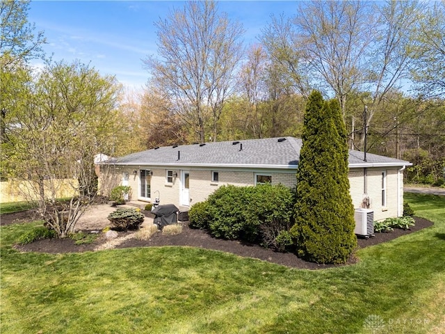 rear view of property with brick siding, a patio area, entry steps, a lawn, and central air condition unit