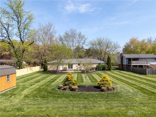 view of yard with fence and an outdoor structure