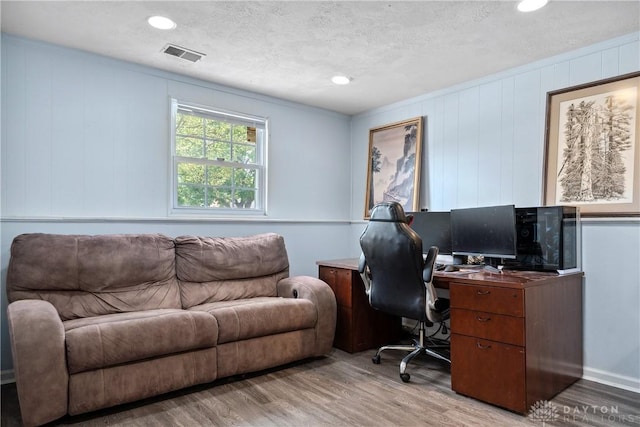 office area featuring recessed lighting, a textured ceiling, visible vents, and light wood-style flooring