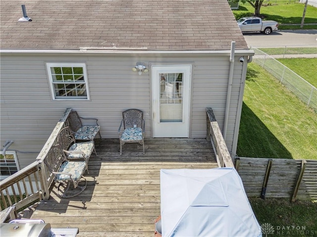 wooden terrace featuring a yard and fence