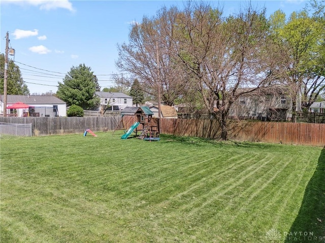 view of yard featuring a playground and a fenced backyard