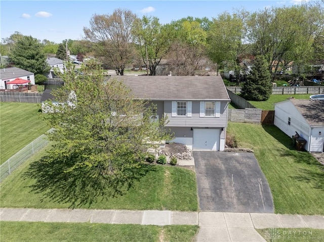 view of front of home featuring fence, an attached garage, driveway, and a front lawn