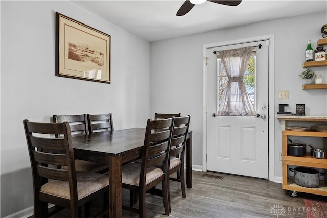 dining space featuring baseboards, ceiling fan, visible vents, and wood finished floors