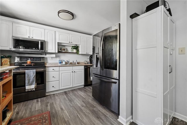 kitchen with light countertops, dark wood finished floors, white cabinets, and stainless steel appliances