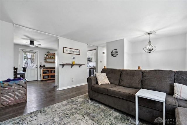 living area with baseboards, wood finished floors, and ceiling fan with notable chandelier