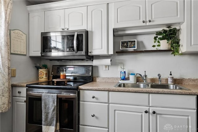 kitchen featuring a sink, white cabinets, open shelves, and stainless steel appliances