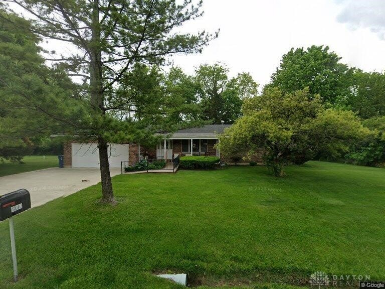 view of front of house with driveway, a front lawn, and brick siding
