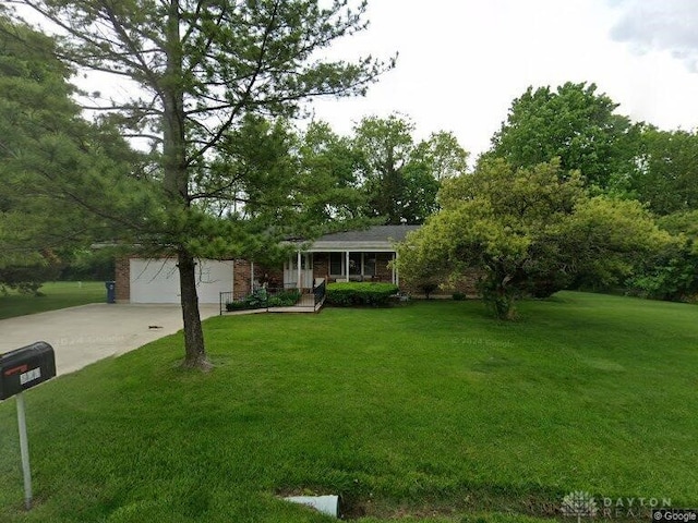 view of front of house with driveway, a front lawn, and brick siding