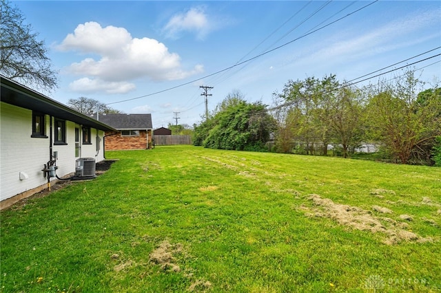 view of yard featuring fence and central AC unit