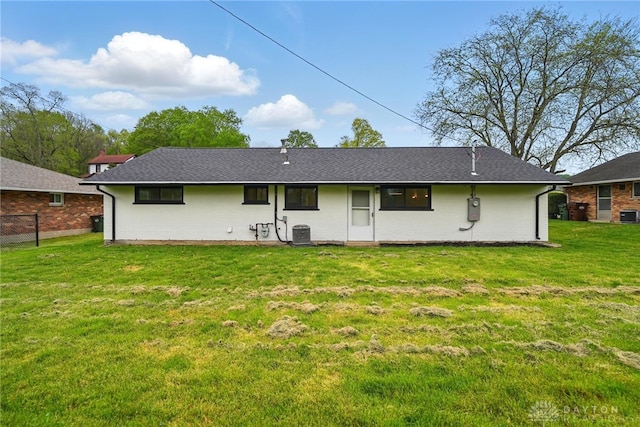 back of house with central AC unit, a yard, and brick siding