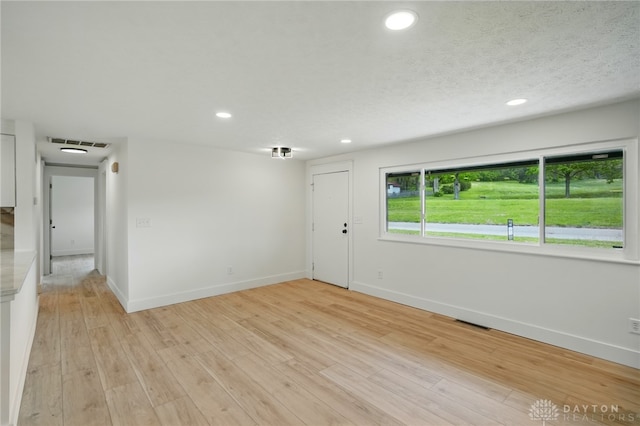 spare room with recessed lighting, baseboards, and visible vents