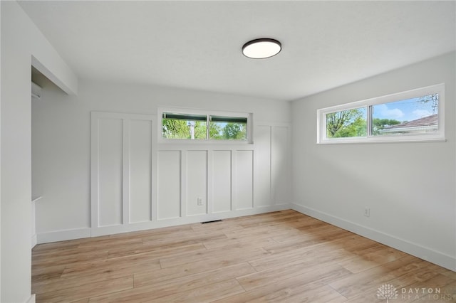 unfurnished room featuring baseboards, visible vents, and light wood finished floors