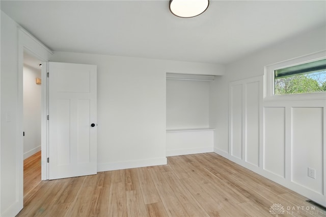 unfurnished bedroom featuring a closet, light wood-style flooring, baseboards, and visible vents