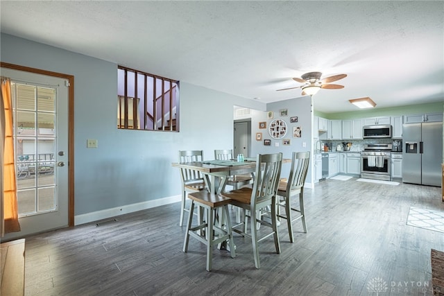 dining space featuring baseboards, ceiling fan, wood finished floors, and visible vents