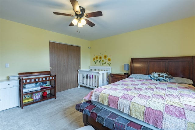 bedroom featuring light colored carpet, a ceiling fan, and a closet