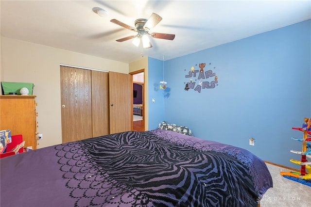 carpeted bedroom with a ceiling fan and a closet