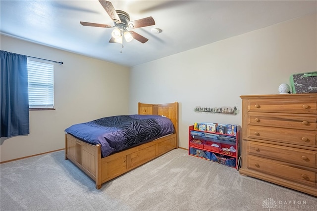 bedroom with ceiling fan, light carpet, and baseboards