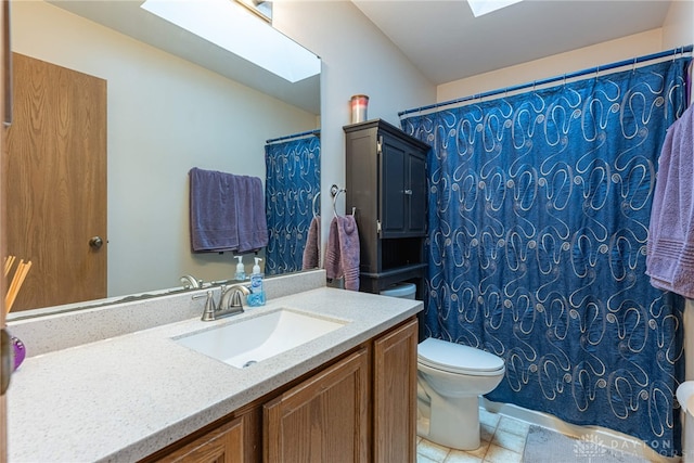 full bathroom with a skylight, vanity, toilet, and curtained shower