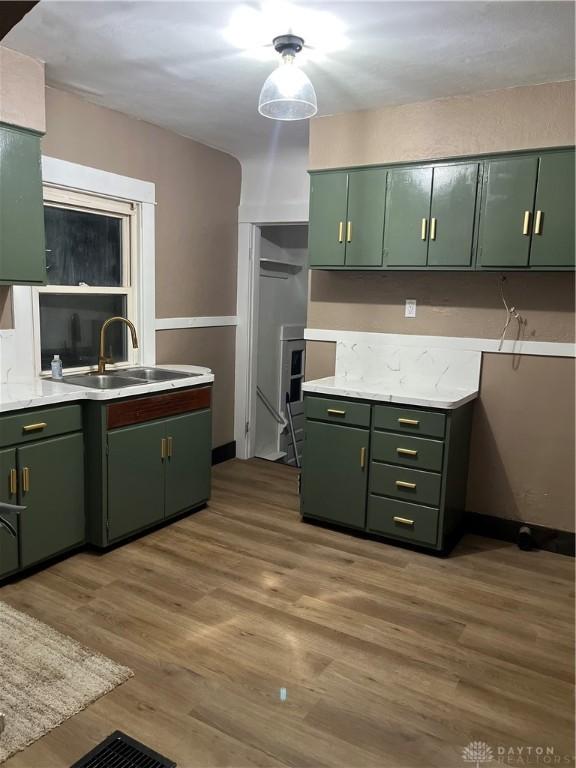 kitchen with a sink, light countertops, and green cabinetry