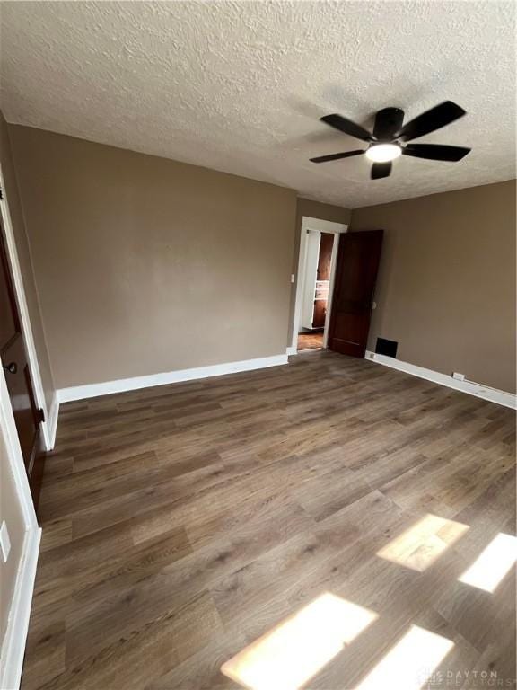 spare room featuring baseboards, a textured ceiling, ceiling fan, and wood finished floors