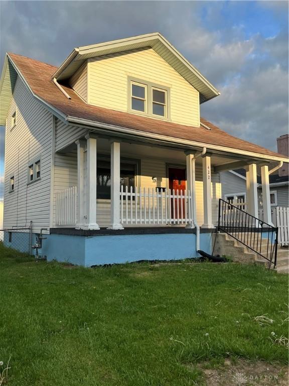 view of front of home with covered porch and a front yard