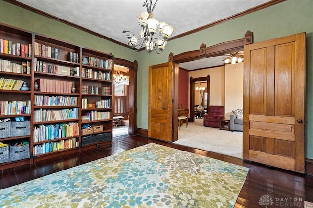 sitting room featuring ornamental molding, a notable chandelier, and dark wood-style floors