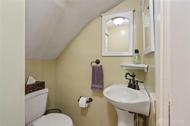 bathroom with toilet, baseboards, a sink, and lofted ceiling