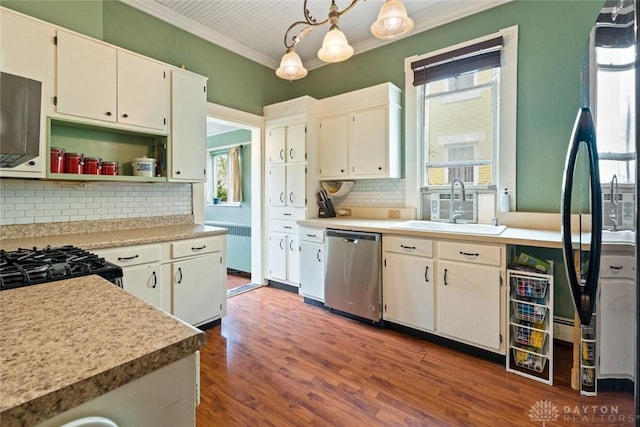 kitchen featuring a sink, crown molding, black appliances, and plenty of natural light