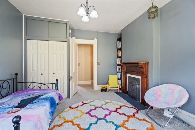 carpeted bedroom with baseboards, a fireplace with flush hearth, and a closet
