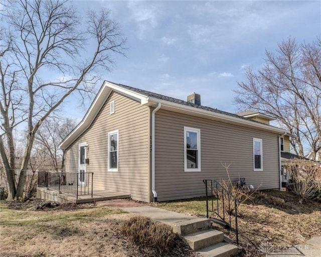 view of property exterior with a wooden deck and a chimney